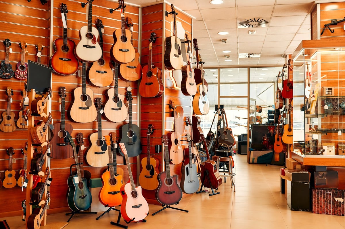 An assortment of guitars hanging on the walls of a musical instrument store